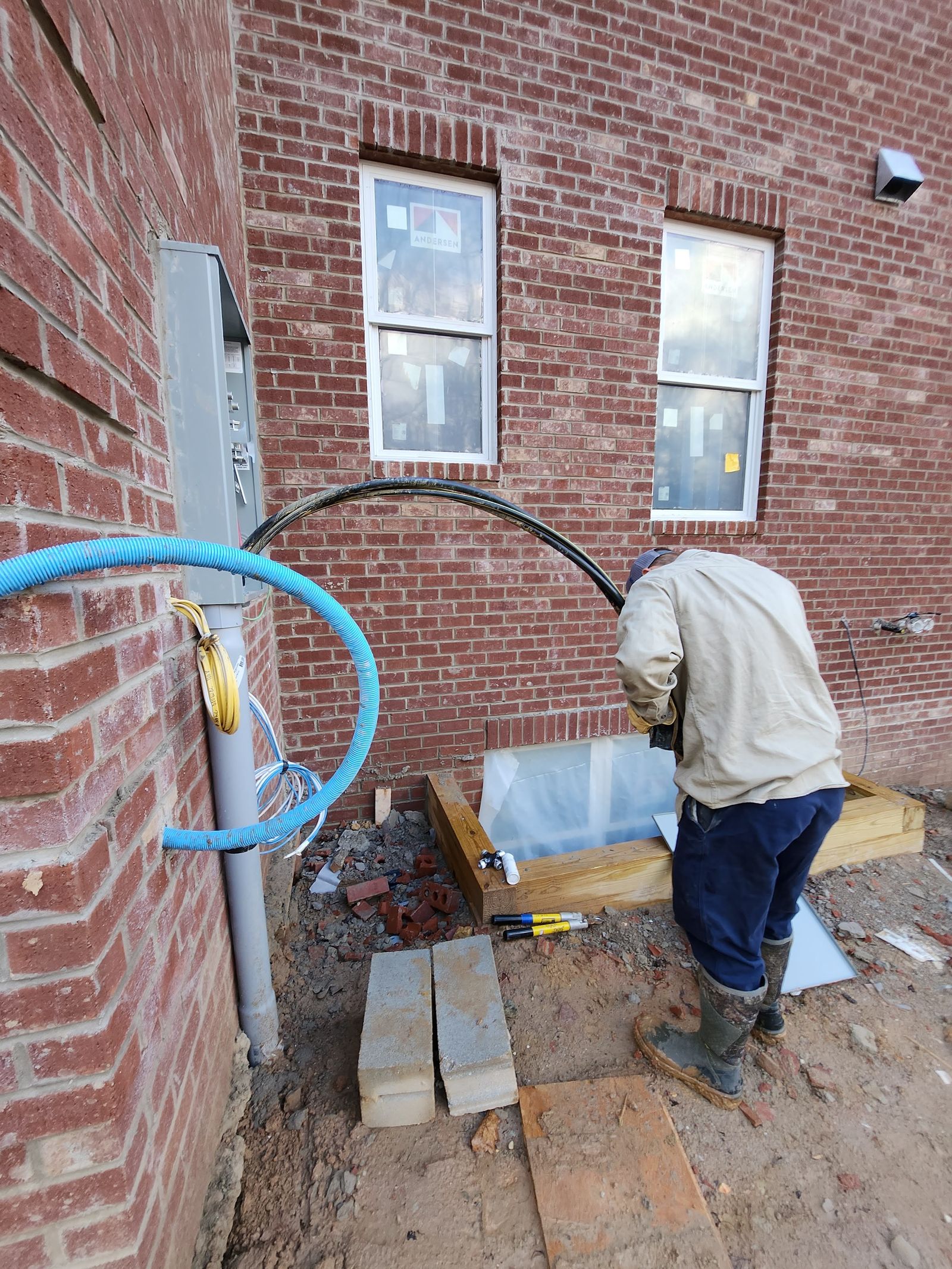 Masonry work in progress with materials staged at the elevation