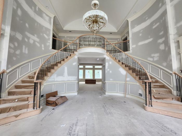 Double staircase and entrance hall during finishing