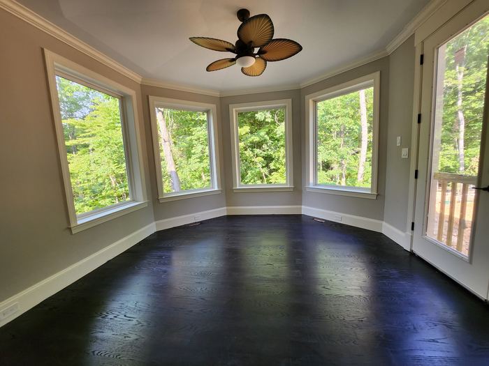 Finished room with hardwood flooring and bay window