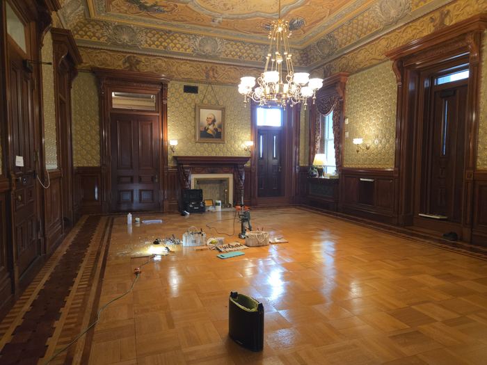 Floor refinishing in progress in an occupied historic building