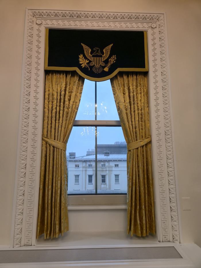 Full-length drapery and valance installed at a window in a formal institutional room
